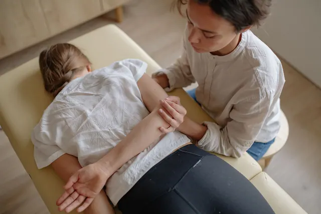 A woman receiving chiropractic treatment on a massage table for relaxation and health. Chiropractic practice daily workflow and SOP guide