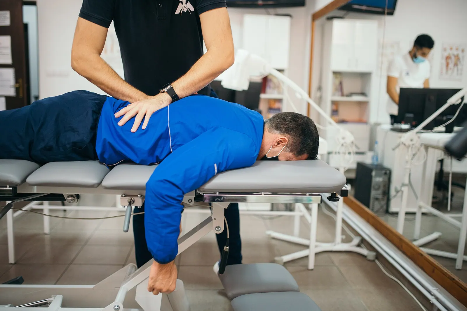 Chiropractor adjusting patient's lower back. How a chiropractic practice turns customers into referrals